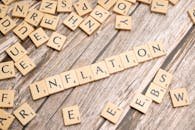 Wooden letter tiles forming the word 'inflation' on a rustic wooden surface, symbolizing economic themes.