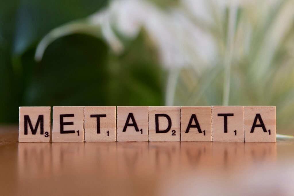 Close-up of the word 'metadata' spelled out with wooden Scrabble tiles on a table.